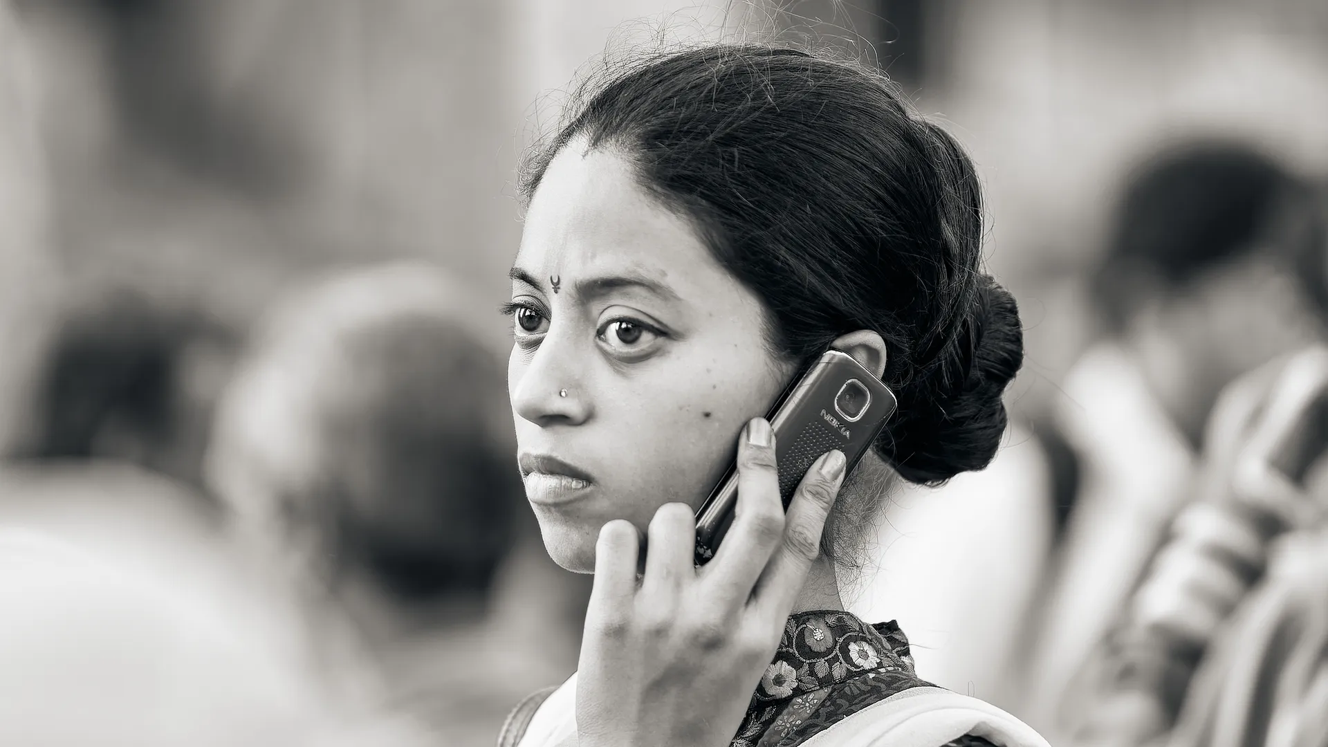 Black and white portrait of an Indian woman talking on a mobile phone, Mumbai, India